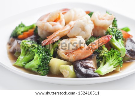 Stir-fried mixed vegetables and prawn in dish on white background.