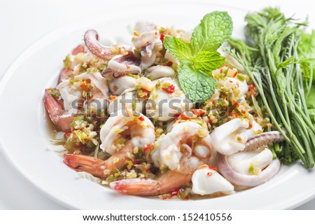 Spicy seafood salad , prawn , squid , oyster in dish on white background.