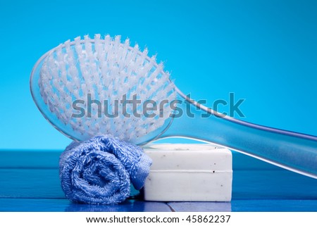 Bathroom scene with body brush massager, soap, blue towel