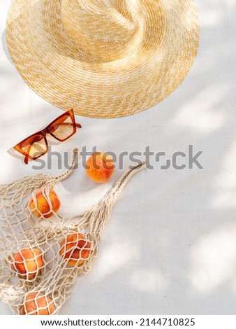 Vintage inspired background with straw hat, female sunglasses and shopper bag with peaches on white towel. Minimalist summer vacation creative still life ​for fashion blog, web, social media, stories. Foto stock © 