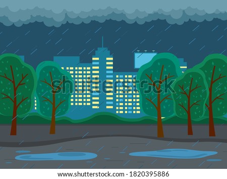 Rainy weather in city at night. Dark clouds looming over the town, goes rain, big puddles on the road. Cityscape with large city buildings with luminous windows, trees in the park in the evening