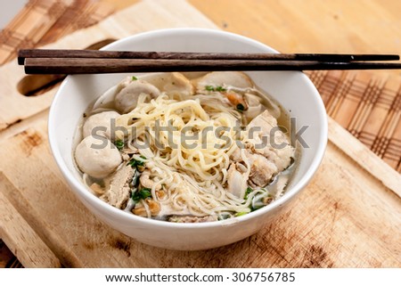 Rice Noodles Bone Soup with Meat Balls and Fish Balls on wood background,Thai food.