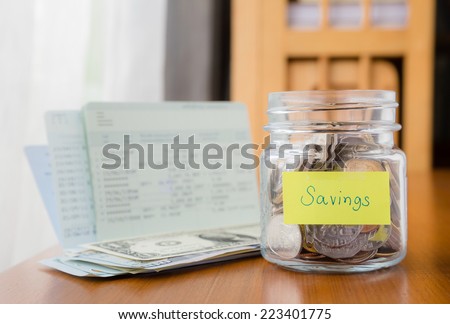 Many world coins in money jar with savings label on jar, concept to financial planning