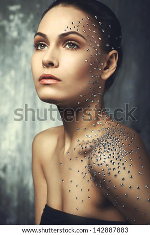 beautiful girl with elements of crystals on the face and body