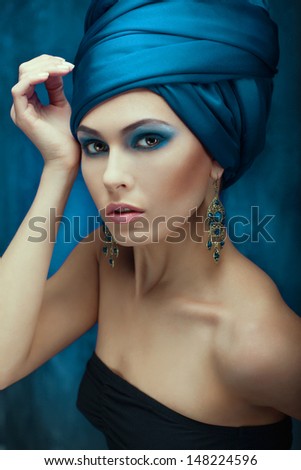 girl in oriental style. turban and earrings highlight its beauty