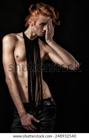 red-haired man with a naked torso and black pants