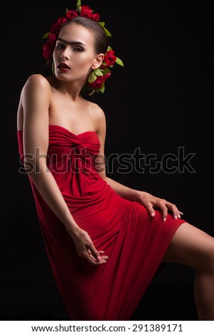 young woman in a red dress with flowers on the head, shot on a black background