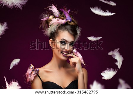 beautiful and young woman with feathers and birds on the head and shoulder