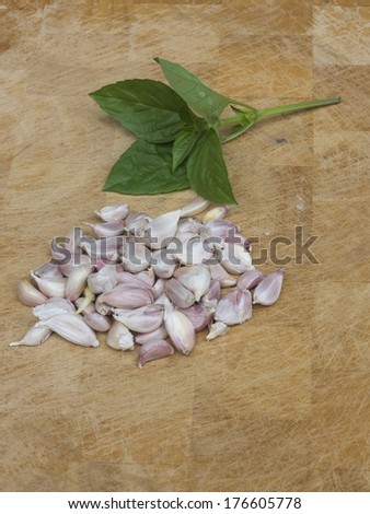 Garlic clove and basil leaf  on wooden background