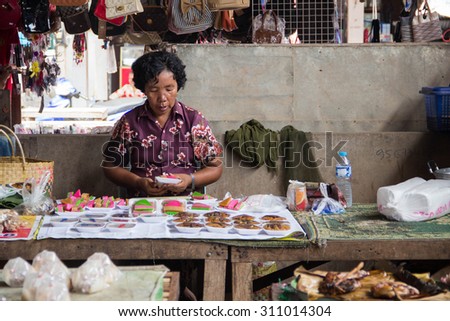 XAIGNABOULI, LAOS -6 JUNE 2014- Merchant packed local dessert in her shop in local market