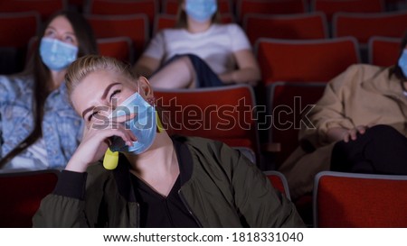People in masks watch funny movie. Media. People in medical masks sit in movie theater and laugh while watching movie. Opening of cinemas during pandemic coronavirus Stock fotó © 