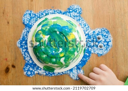 handicraft toys. we play a fairy tale at home.  Childhood fantasy.  Workshop of art and creativity at kindergarten. Painting, coloring and gluing. Green turtle from waste. sort, recycle, reuse.