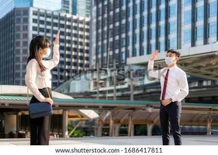 Asian business man and woman greet and say hello with business colleague and wearing mask standing distance of 1 meter distance protect from COVID-19 viruses for social distancing  for infection risk 