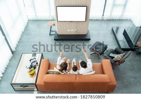 Top view of Asian happy family sitting and watching television in living room at home and spent quality time together for activity in vacation day, holiday, happiness or lifestyle concept.