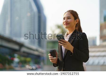 Similar – Image, Stock Photo Young businesswoman using smartphone and holding documents