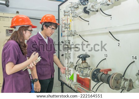 Chemical engineer student checking equipment in control room for training