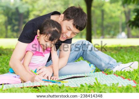 Happy kid and dad paint together in park