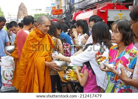 LOP BURI  AUGUST 13 : Thai people give food offerings to a Buddhist monk, Songkran Day in Thailand on August 13, 2014 in Lop Buri Thailand.