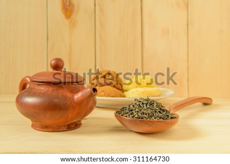 Teapot chinese style, Cup of chinese tea and spoon of dried tea leaves on wooden background