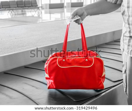 Traveler his luggage at conveyor belt in arrivals lounge of airport terminal building