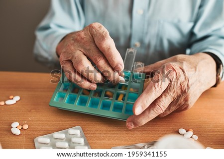 Similar – Image, Stock Photo Senior man organizing his medication into pill dispenser. Senior man taking pills from box