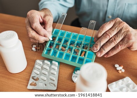 Image, Stock Photo Senior man organizing his medication into pill dispenser. Senior man taking pills from box