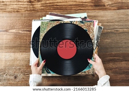 Similar – Image, Stock Photo Playing vinyl records. Listening to music from vinyl record player. Retro and vintage music style. Woman holding analog LP record album. Music passion