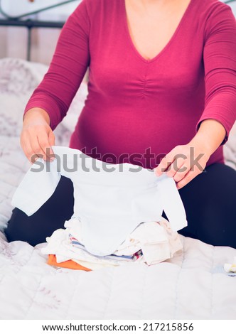 Pregnant woman packing hospital bag preparing for labor