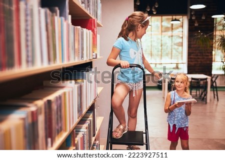 Similar – Image, Stock Photo Two schoolgirls spending time in school library. Primary school students learning from books. Children having fun in school club. Doing homework