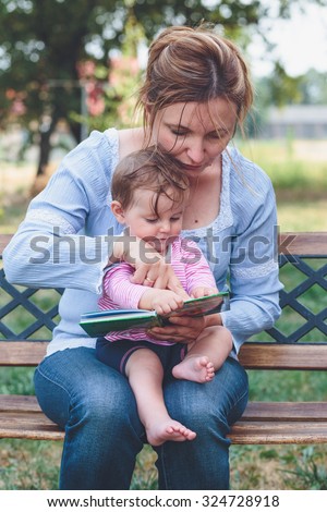 Mom reading a book her little daughter