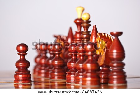 Chess pieces on board (focus on center pawn)