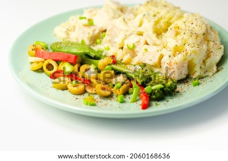 Tender pieces of smoked haddock and pollock in a creamy cheese sauce sat beneath buttery mash served with vegetables, classic English meal Stockfoto © 
