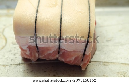 Boneless pork loin joint tied with string on the oven tray, raw meat prepared for baking, traditional meal Foto stock © 