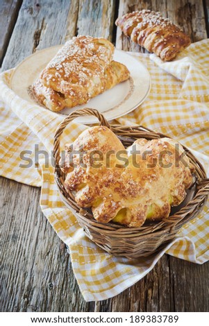 appetizing freshly baked rolls in a basket on a wooden background