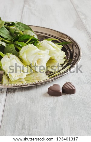 beautiful white roses and chocolates in the form of hearts