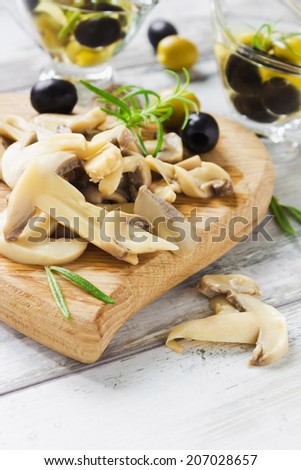 mushrooms on a cutting board and marinated olives with olive oil.health and diet. selective focus