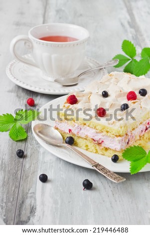 celebratory cake with blueberries and strawberries and strawberry tea on old wooden background.
