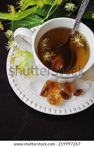 fresh, tasty and healthy linden tea and lumps of sugar on a dark background.health and diet food