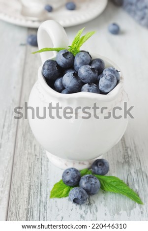 fresh ripe blueberries in a beautiful old cup on old wooden background.health and diet food.