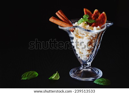 curd dessert with sliced fruit, cinnamon and fresh mint leaves on a black background.health and diet food