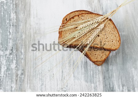 slices of rye bread and ears of corn wheat on a light wooden background.health and diet food. copy space background