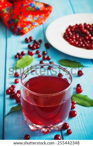 fresh cranberry juice in a glass and fresh cranberries on a blue wooden background.health and diet food