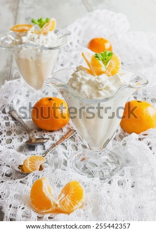 cottage cheese dessert with orange slices in the beautiful ice-cream bowls on the table. health and diet food