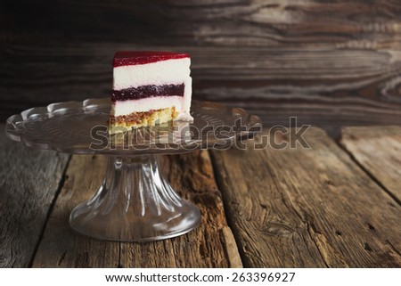 piece of cake with a cream puff on a glass base on the old wooden background. holidays and events. copy space background