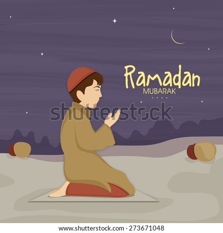 Cute little Muslim boy in traditional dress praying (reading Namaz, Islamic Prayer) in night on occasion of holy month Ramadan Kareem celebration.