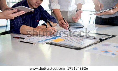 Business people meeting to find analytical ideas pointing to the graph at the office.
