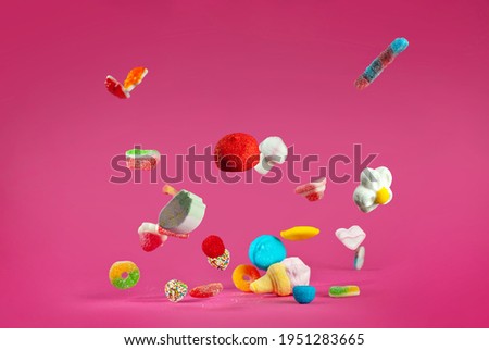 Similar – Image, Stock Photo Many colorful candies fall down in front of a black background