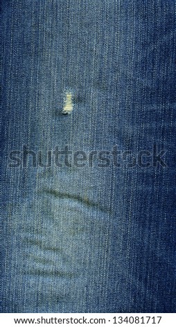 High resolution scan of blue denim fabric with a worn-out look.