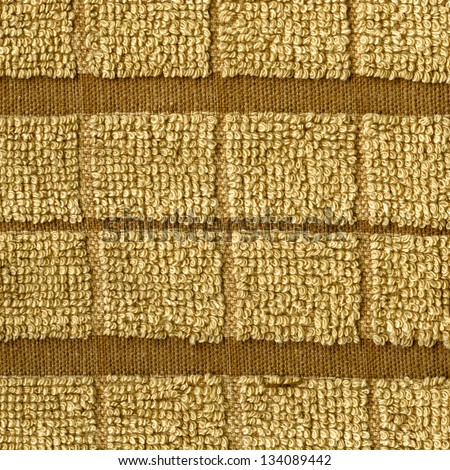 High resolution close up of a beige towel cloth with two darker brown stripes crossing it horizontally.
