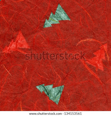 High resolution scan of red rice paper with a pattern of green pine trees decorating its surface.